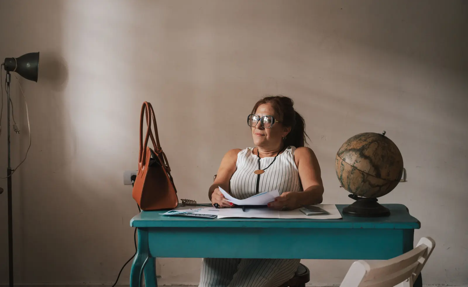 The best coworking spaces in Buenos Aires Woman sitting at a desk with documents and globe, reflecting in Provincia de Buenos Aires.