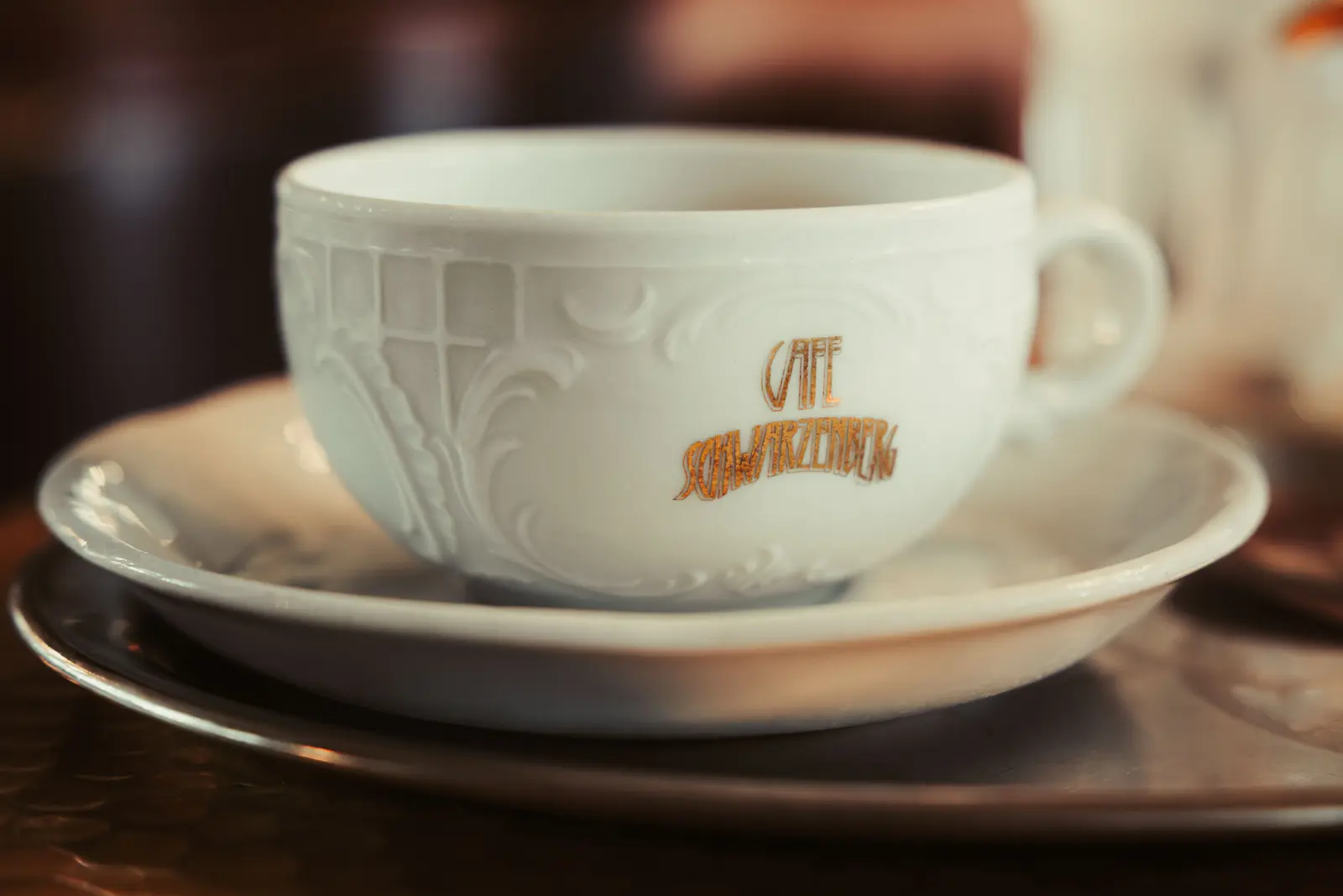 A close-up of a decorative coffee cup at Cafe Schwarzenberg, Vienna, encapsulating classic Viennese ambiance.