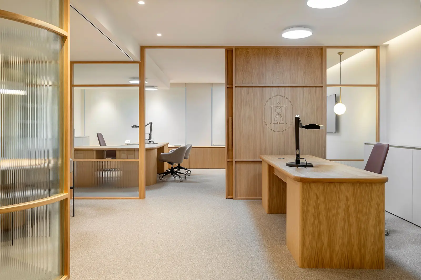 The best coworking spaces in Barcelona Sleek modern office with wooden furniture in Barcelona, featuring bright lighting and open space.