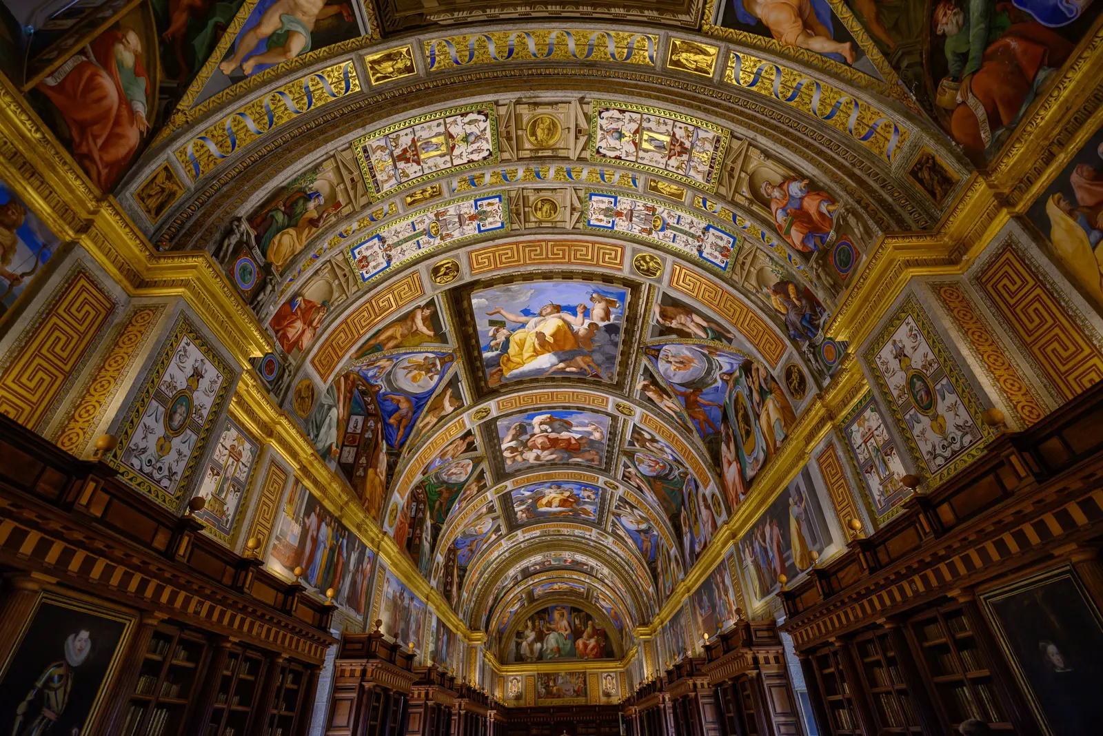 The best places to study in Madrid Intricate ceiling art of El Escorial Library in Madrid, Spain, showcasing classic artistic paintings.