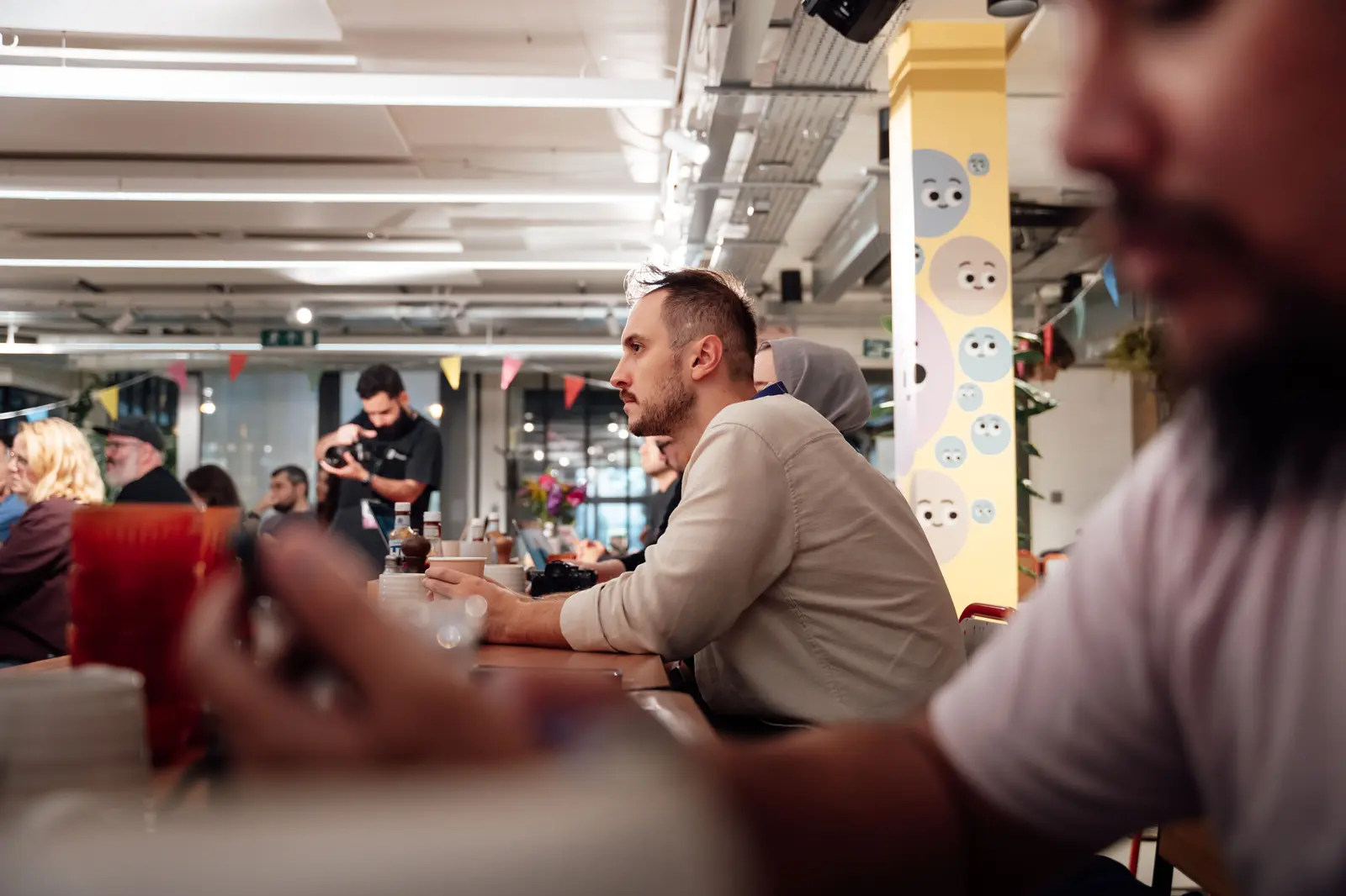 The best coworking spaces in London A diverse group of people engaged in a lively meeting at a modern London workspace, with a focus on collaboration.