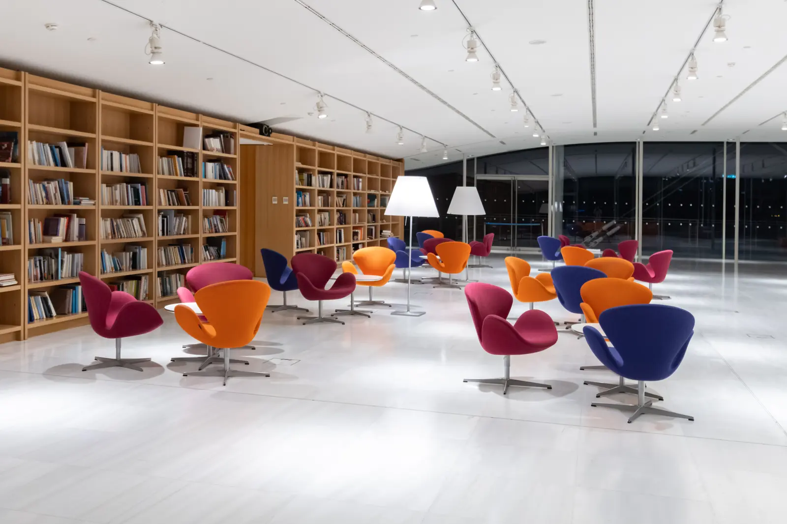 The best libraries to work and study in Athens Spacious library in Athens with vibrant chairs and bookshelves, perfect for reading.