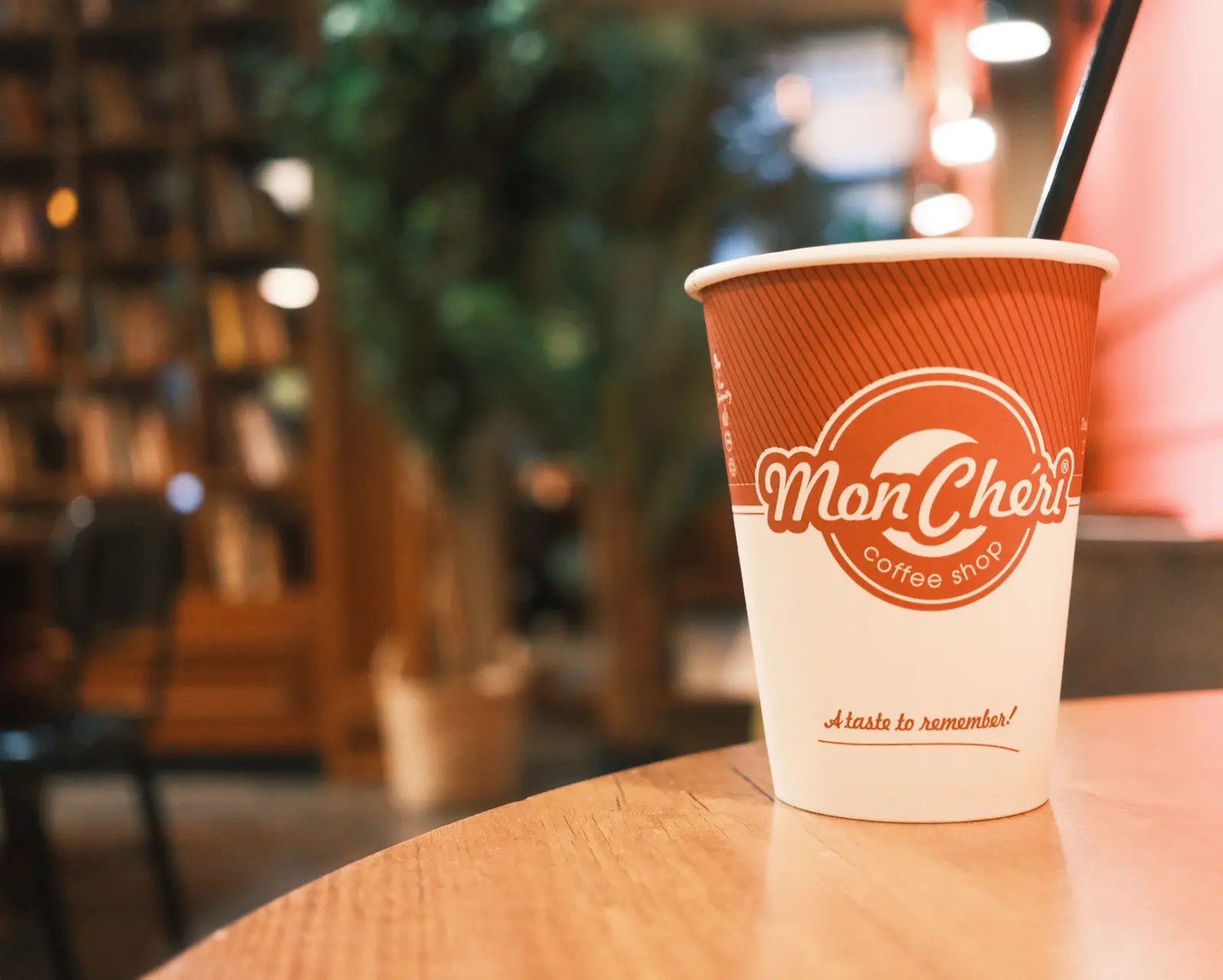 The best cafés to work from in Budapest Warm ambiance in a Budapest coffee shop with a Mon Chéri takeaway cup on display.