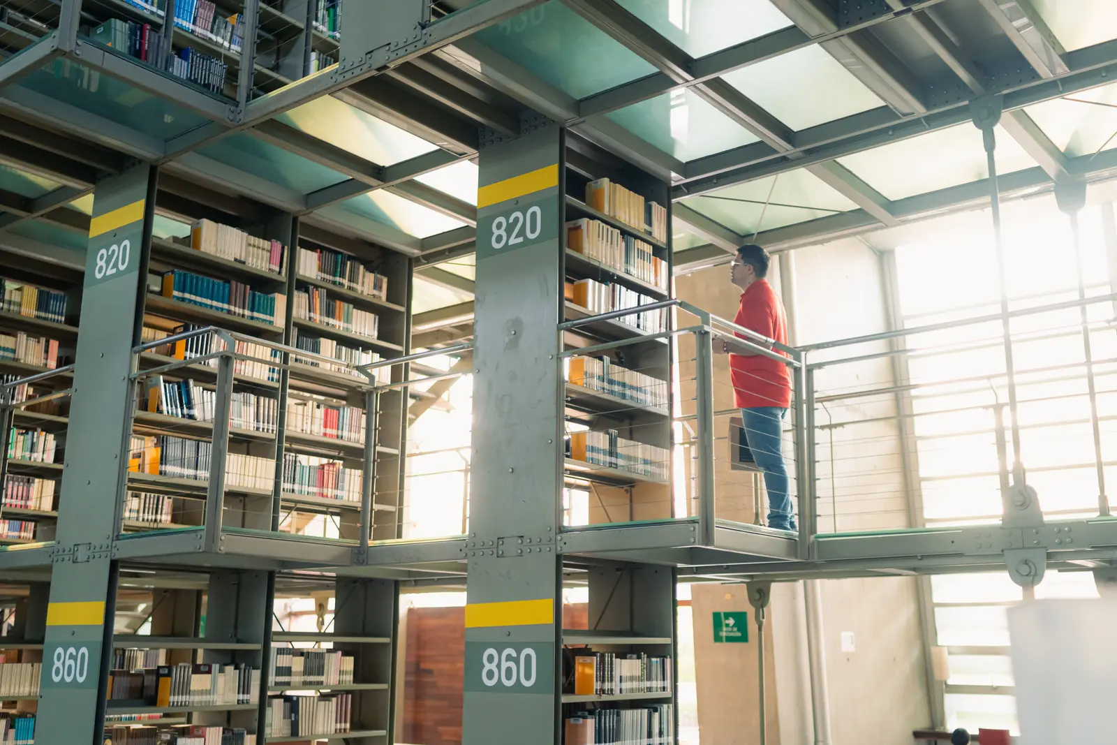 The best libraries to work and study in Mexico City Student browsing bookshelves in a modern library in Mexico City
