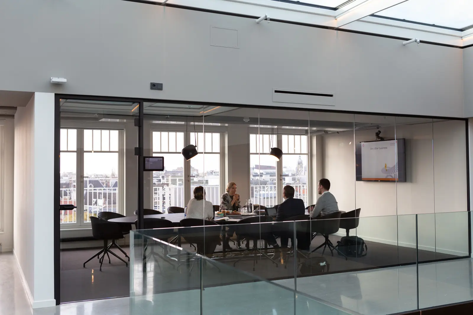 The best coworking spaces in Amsterdam A professional meeting in a modern glass-walled office with city views in Amsterdam.