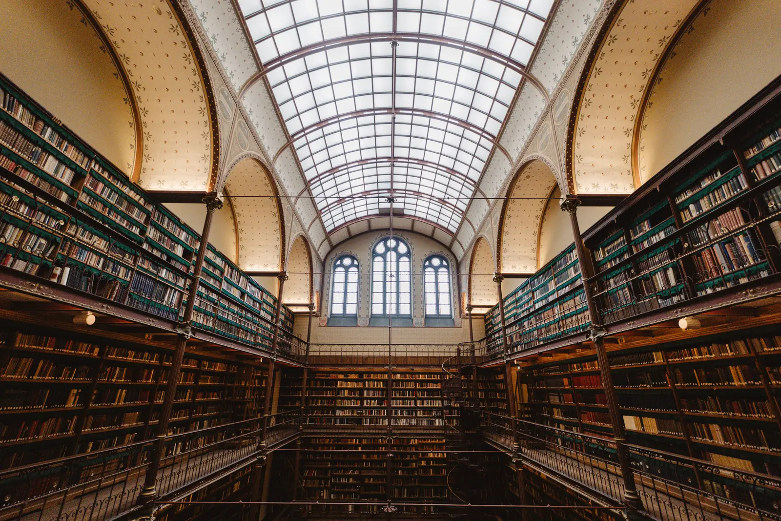 The best places to study in Amsterdam Stunning interior view of a historic library showcasing vast book collections in Amsterdam.