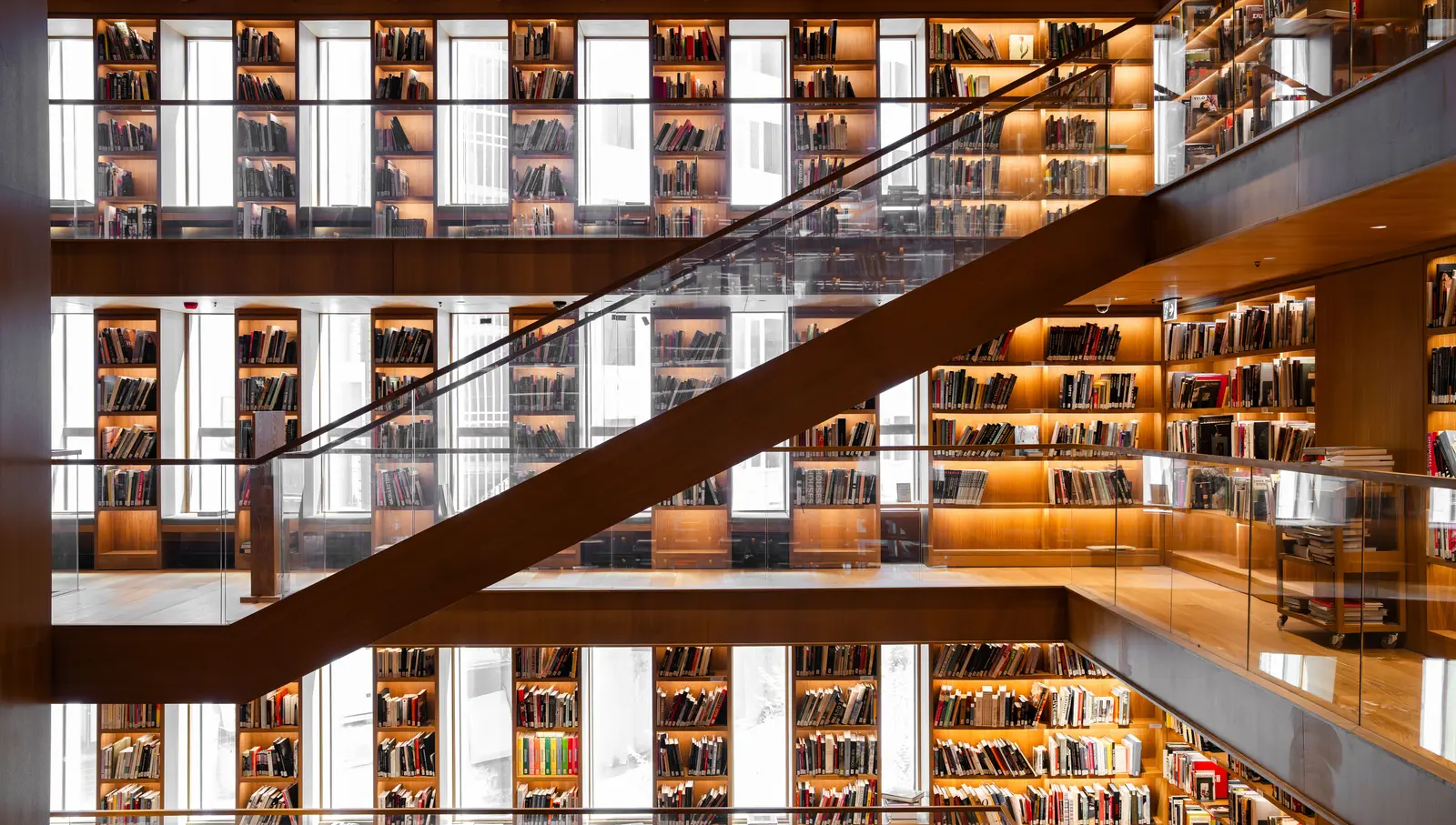 The best libraries to work and study in Istanbul Striking view of a multi-level library with wooden bookshelves and warm lighting in İstanbul.