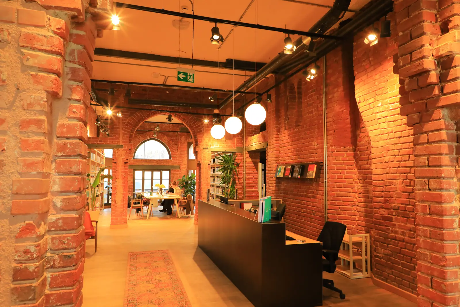The best places to study in Istanbul Warm interior of a public library in Istanbul featuring exposed brick walls and modern lighting.