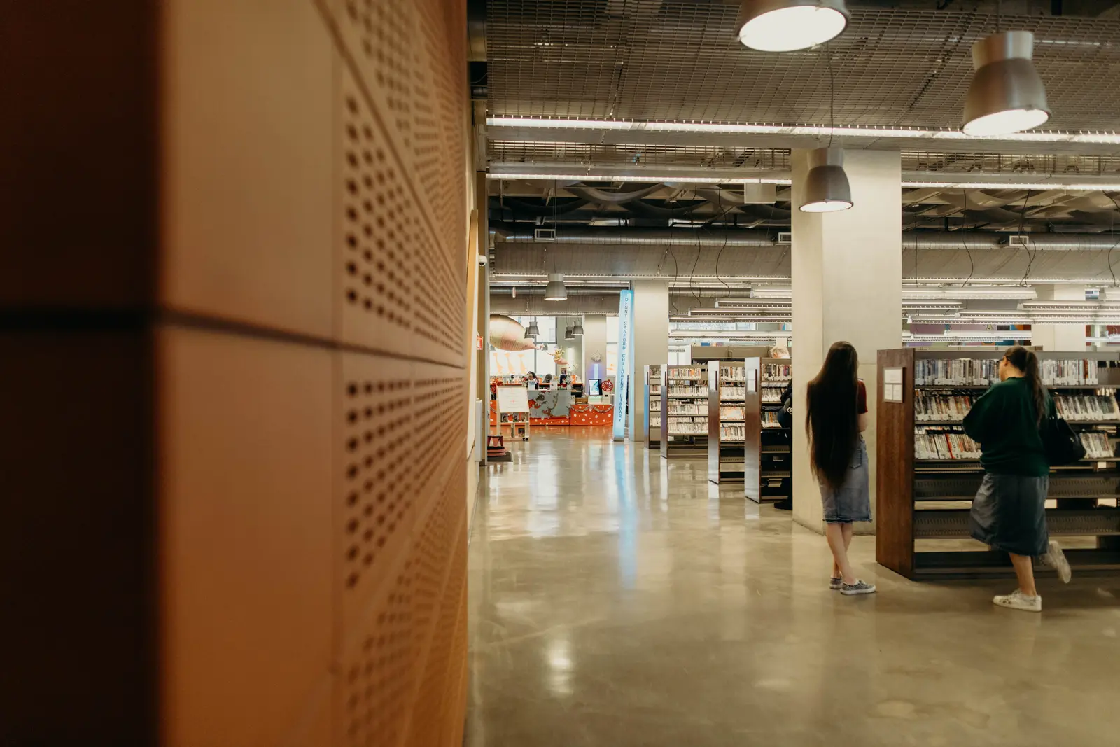 The best libraries to work and study in San Diego Wide view of a modern library interior in San Diego with visitors exploring book collections.
