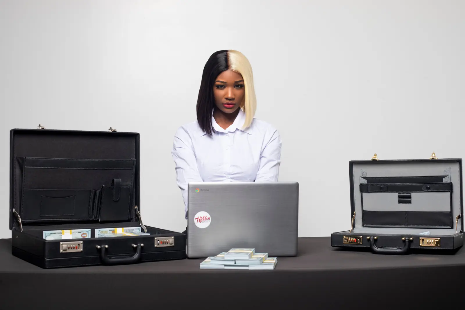 The best coworking spaces in Miami Confident businesswoman working at desk with briefcases and laptop, highlighting professionalism in Miami.