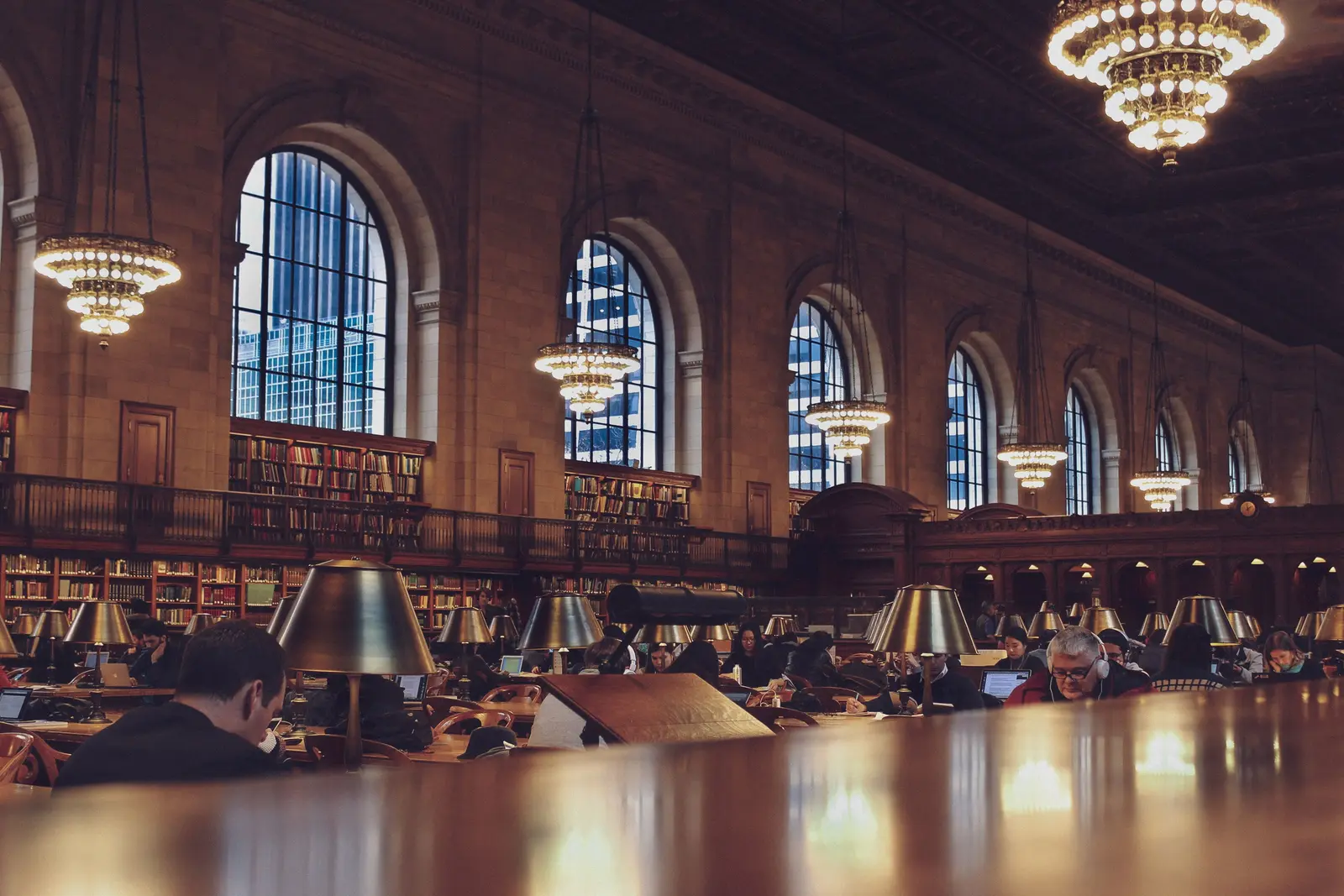 The best places to study in New York Interior view of a bustling reading room with chandeliers at the New York Public Library.
