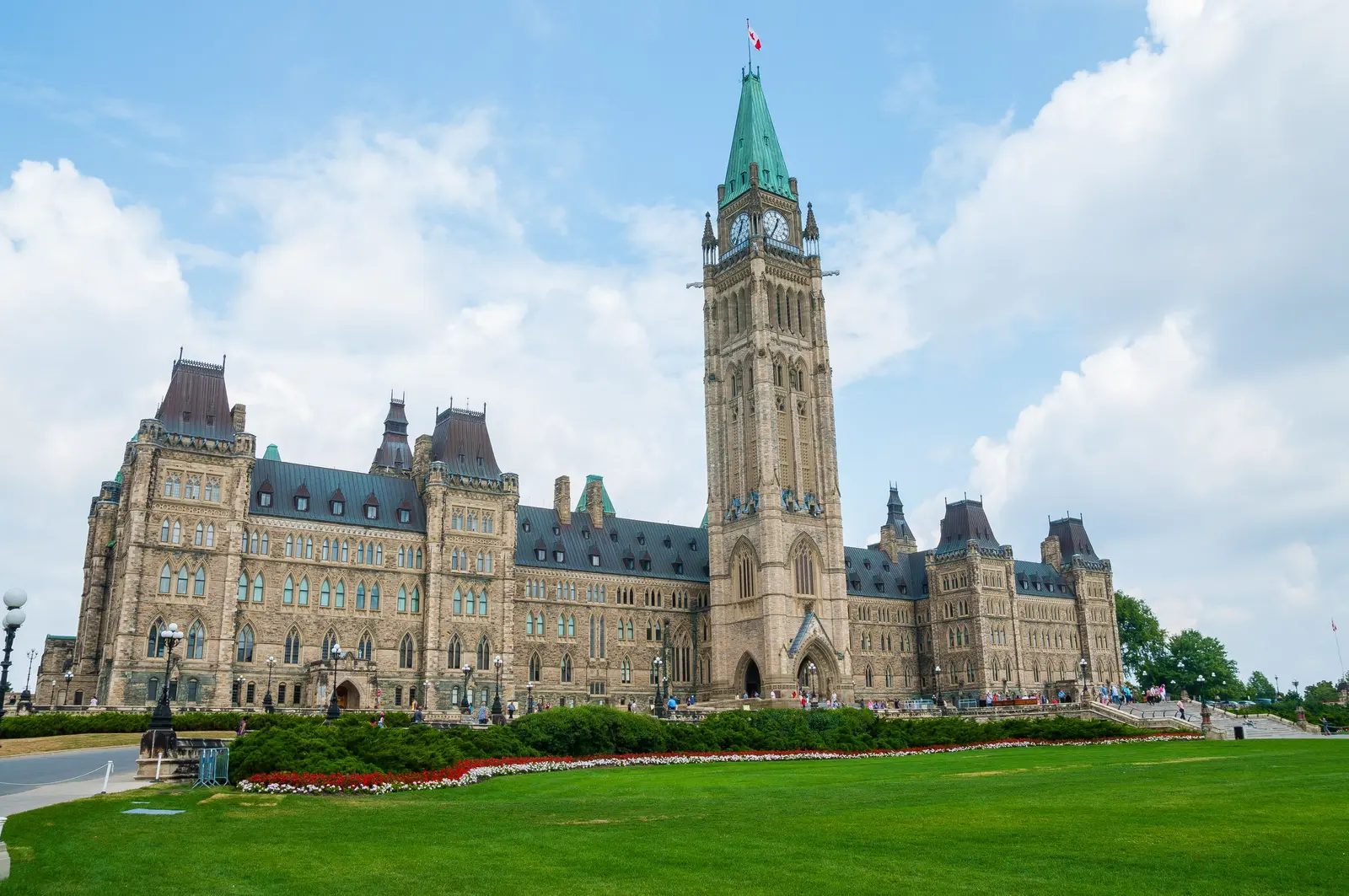 Sunny view of Château Laurier from Major's Hill Park, Ottawa with lush greenery in summer.