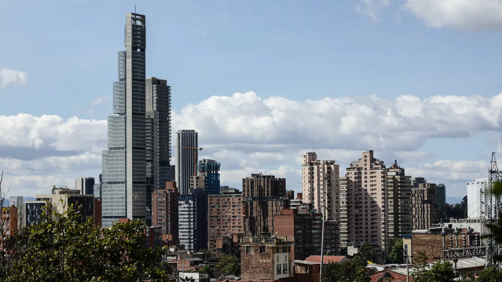 Aerial shot of Bogotá, Colombia, showcasing cityscape and surrounding lush mountains.