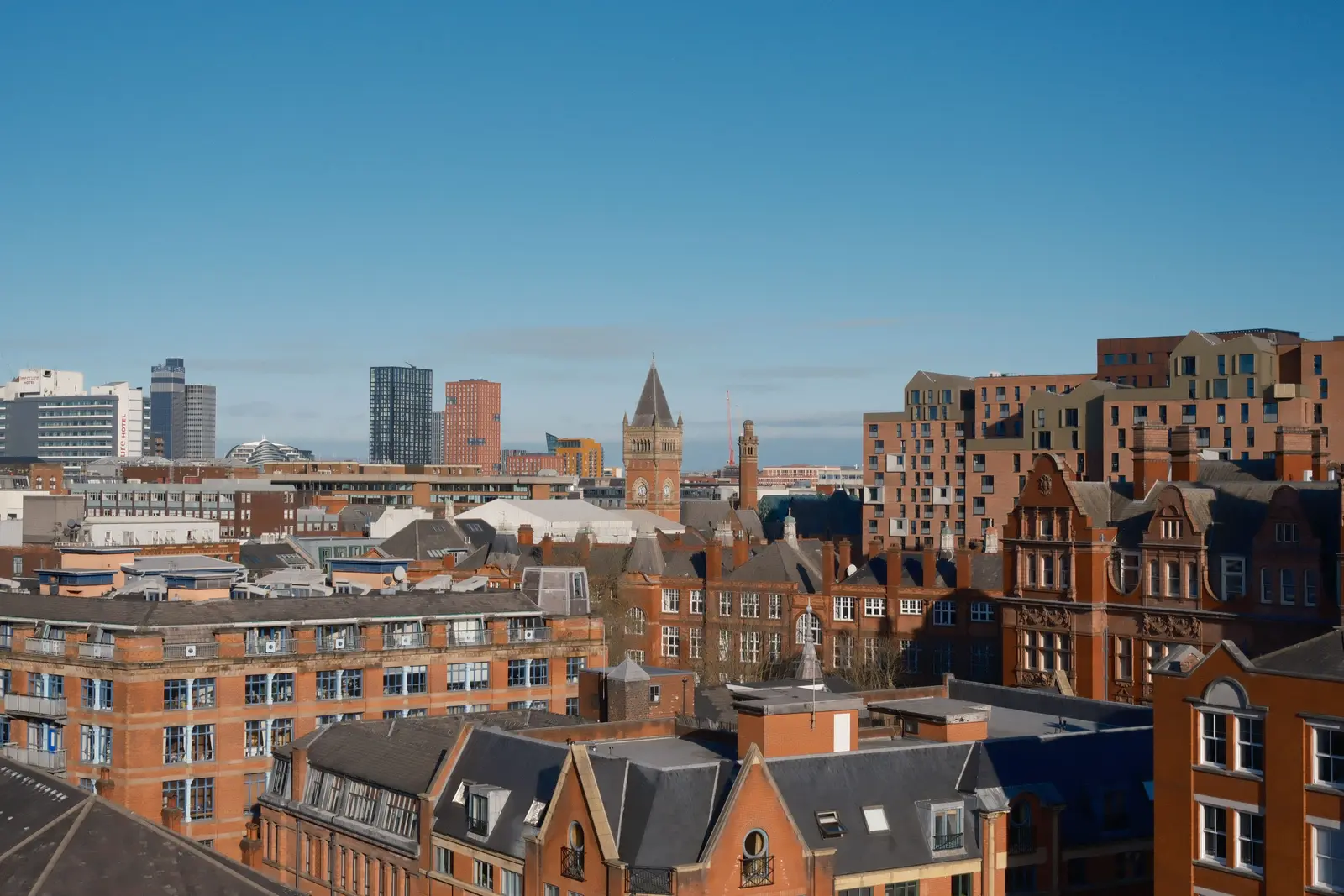 Stunning aerial photograph of Manchester's urban skyline showcasing modern architecture under scattered clouds.