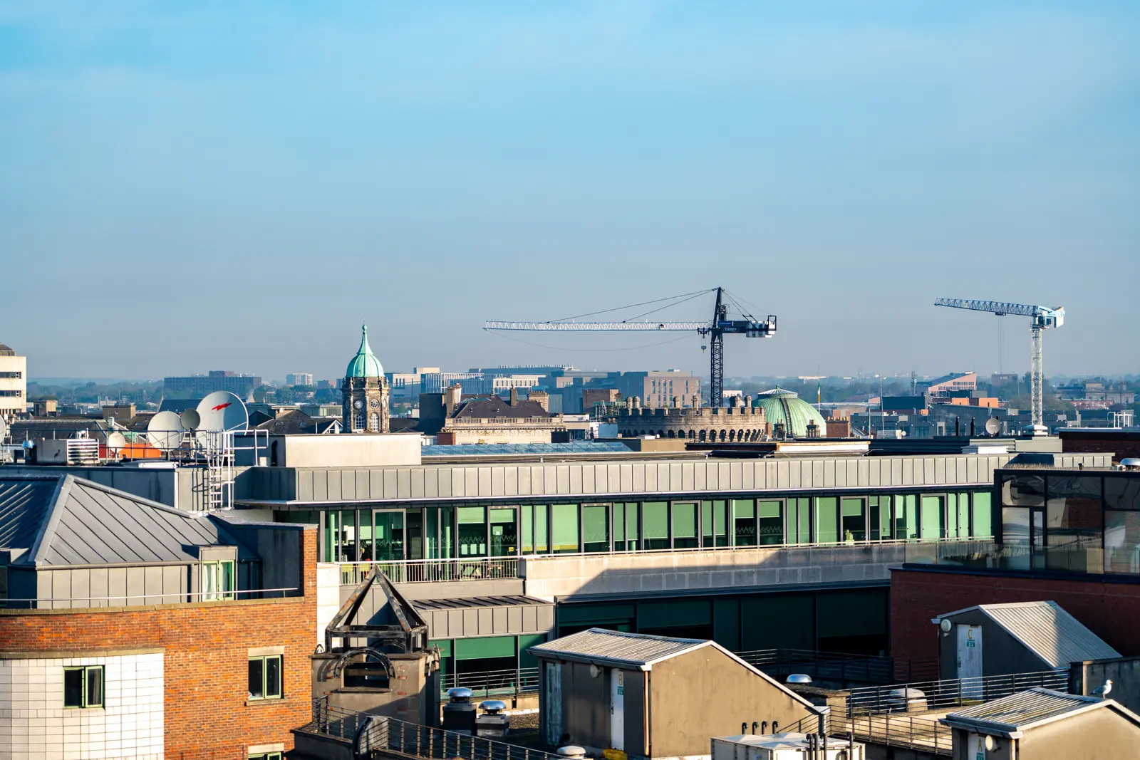 Scenic view of Dublin's Ha'penny Bridge over the River Liffey amidst urban architecture and vibrant city life.